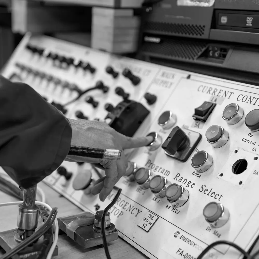 An engineer operating the current-control test panel on TWS Energy Controls equipment